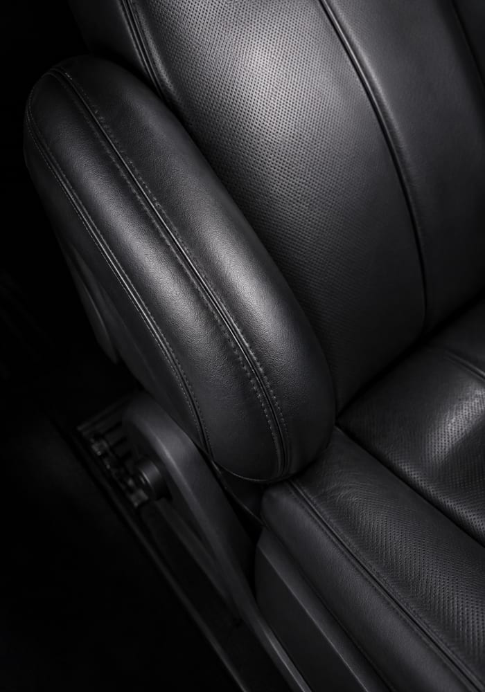 A restored leather seat photographed in raking light.